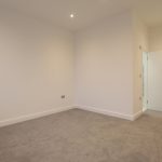 Empty room with carpet and two doors.