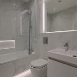 Modern bathroom with marble tiles and fixtures.