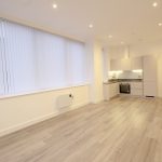 Modern open-plan kitchen and living area with wooden flooring.