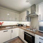 Modern kitchen with white cabinets and appliances.