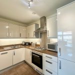 Modern kitchen with appliances and wooden countertops.