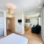 Modern flat interior with bedroom and living room view.