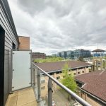 View from a balcony overlooking office buildings.