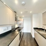 Modern kitchen with sleek countertops and cabinets.