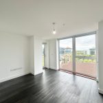 Bright empty room with large window and city view.
