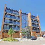 Modern apartment building with parking and greenery