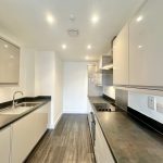 Modern kitchen with sleek cabinets and dark countertops.