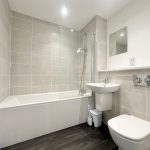 Modern bathroom with bathtub, sink, and toilet.