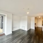Modern open-plan kitchen and living area with balcony.