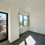 Bright empty room with balcony view.