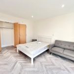 Minimalist bedroom with bed and grey sofa