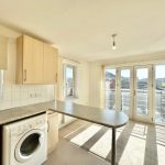 Bright kitchen with washing machine and patio doors