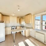 Bright kitchen with wooden cabinets and large window.