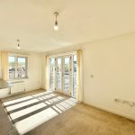 Bright empty living room with large windows and balcony.
