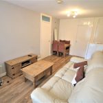 Cosy living room with sofa and wooden furniture.