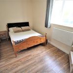 Cosy bedroom with wooden flooring and double bed.