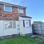 Brick house with white door and satellite dishes.
