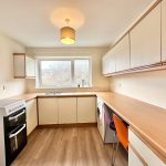 Modern kitchen with wooden countertops and white cabinets.