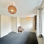 Bright room with carpet and two pendant lights.