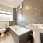 Modern bathroom with bath, shower, sink, and toilet