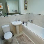 Modern bathroom with bathtub, sink, and toilet.