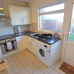 Modern kitchen with appliances and garden view.