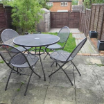 Outdoor patio with metal table and chairs.