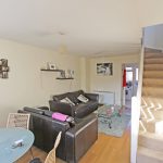 Modern living room with stairs and dining area