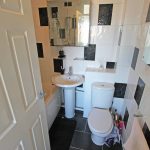 Small bathroom with sink, toilet, and bathtub.