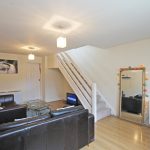Modern living room with staircase and leather sofa