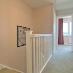 Bright hallway with white railing and artwork