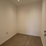 Small empty room with wooden floor.