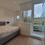 Modern bedroom with large window and bed