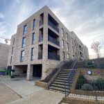 Modern brick apartment building with stairs and railings.