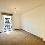 Spacious, bright empty room with large window view.