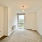 Empty room with large window and light fixture.