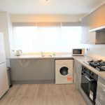 Modern kitchen with appliances and large window.