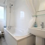 Modern white bathroom with bathtub and sink