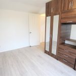 Modern bedroom with wooden wardrobe and white walls.