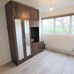 Bedroom with wardrobe and large windows.