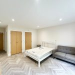 Modern bedroom with grey sofa and white bed.