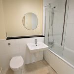 Modern bathroom with shower, sink, toilet.