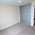 Empty room with wardrobe and grey carpet