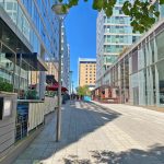 Modern business district with glass buildings and walkway.