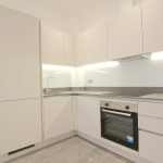 Modern kitchen with white cabinets and built-in appliances.