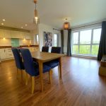 Modern open-plan kitchen and dining area with windows.