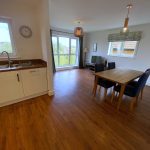 Open plan kitchen and dining room with wooden floor.