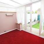 Room with red carpet and garden view