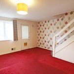 Spacious room with red carpet and leaf wallpaper.