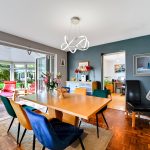 Modern dining room with vibrant chairs and artwork.